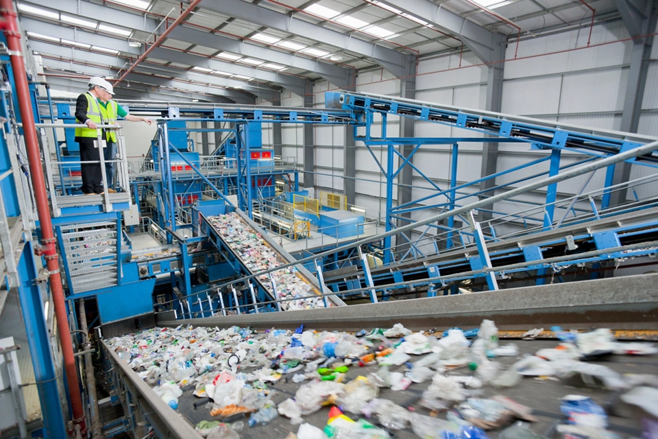 Wide shot of Businessman and worker talking on platform above conveyor belts in recycling plant; Shutterstock ID 1840555168; purchase_order: Enterprise MARCOM; job: Circular Plastics eBook; client: Media All Media License; other: 