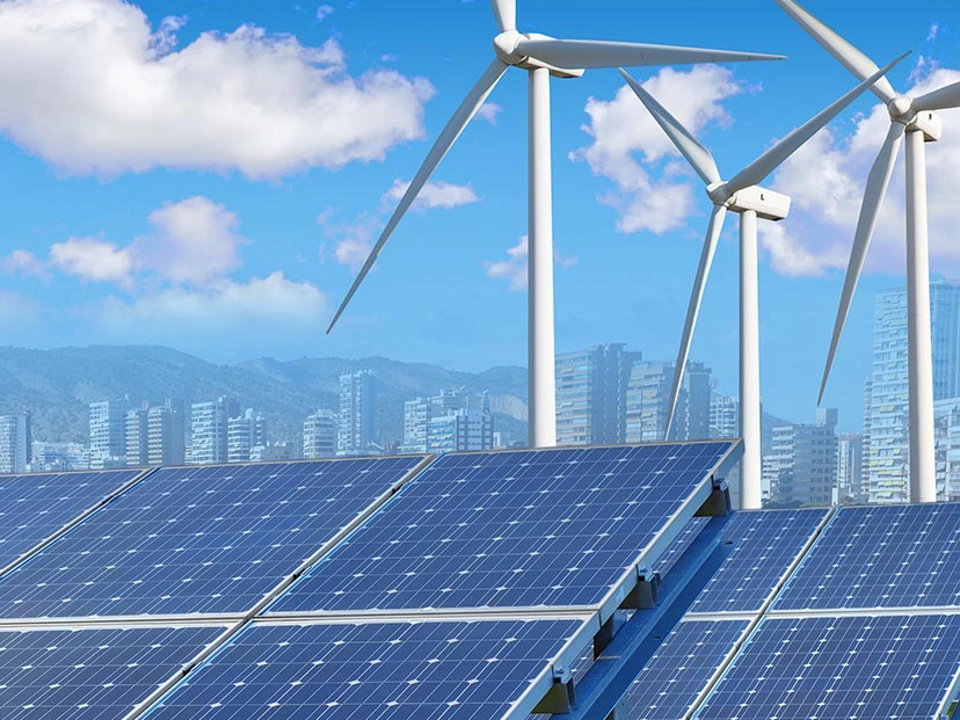 solar panels and wind turbines under blue sky and clouds with city on horizon