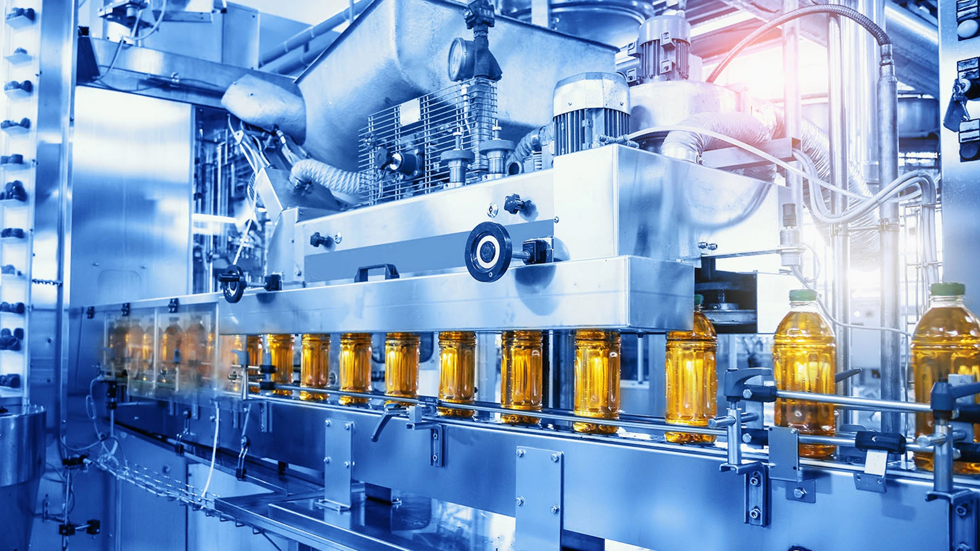 Beverage factory, Conveyor belt with juice in bottles, Industrial Interior in blue color, food and drink production line process.