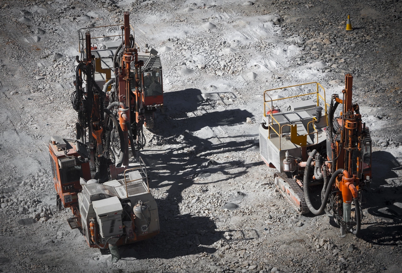Drilling machine makes bore holes for explosives in open cast mine. Lithium Mine in Western Australia. Spodumene ore from the open cast mine.