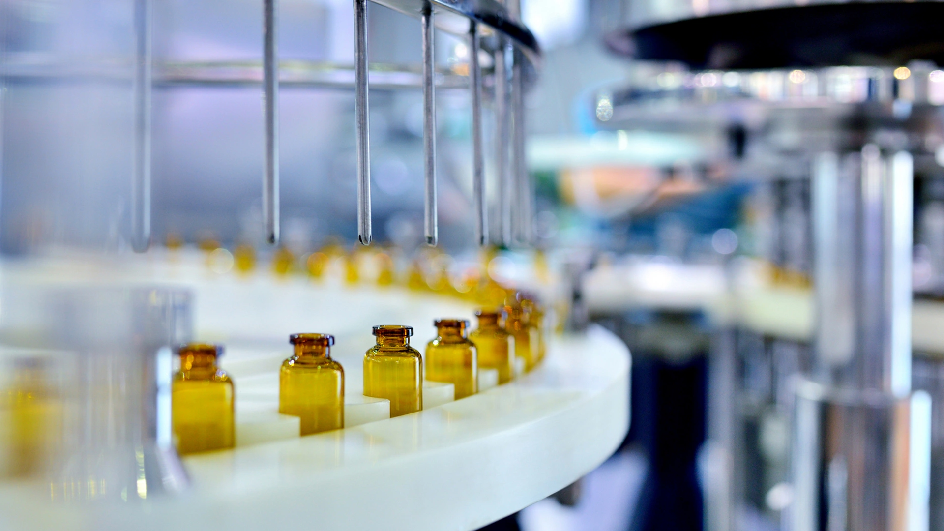Cloes-up of brown glass bottle filling at production line.