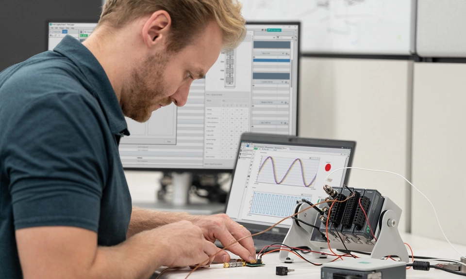 Engineer using NI hardware and software for data acquisition in a laboratory setting.