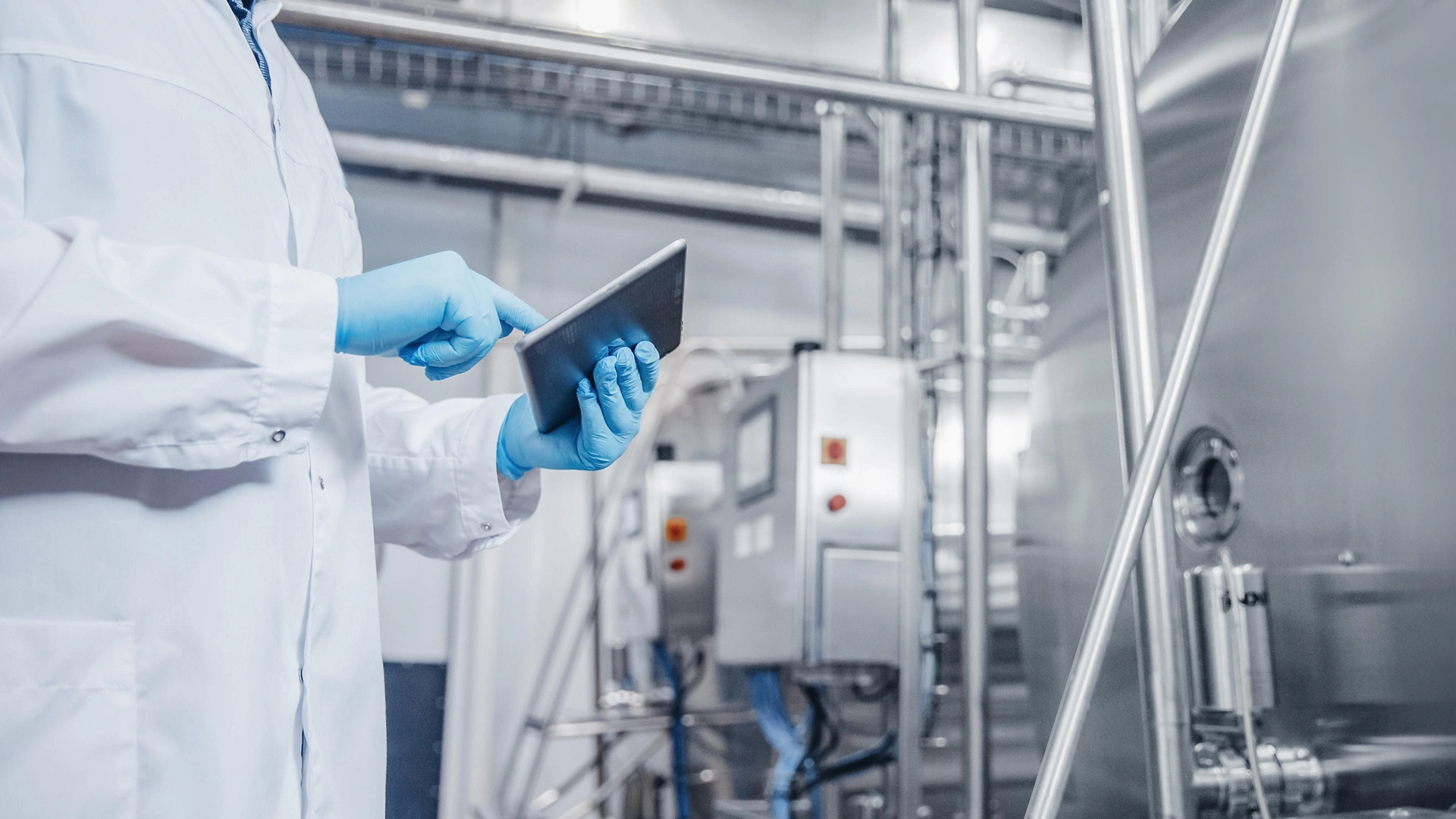 Concept control food industry banner. Factory worker inspecting production line tanker in of dairy with computer tablet.