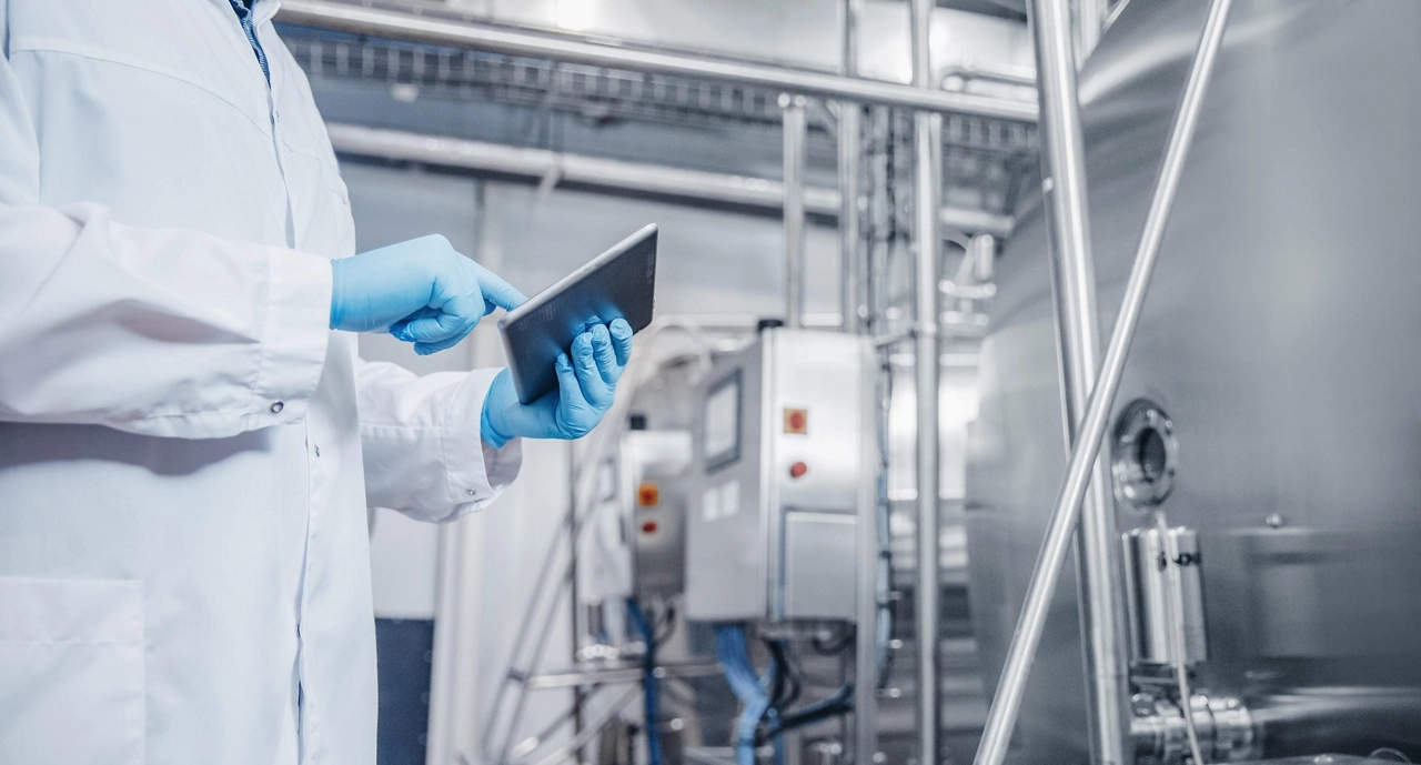 Concept control food industry banner. Factory worker inspecting production line tanker in of dairy with computer tablet.
